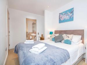 a bedroom with a large bed with towels on it at 404 By The Bridge Apartment in Inverness