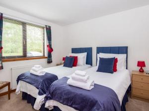 dwa łóżka z ręcznikami na górze w sypialni w obiekcie Holm Dell Apartment w mieście Inshes