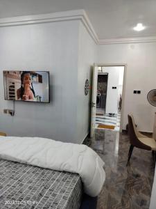 een slaapkamer met een flatscreen-tv aan de muur bij UCLAS Gorgeous Apartment in Port Harcourt