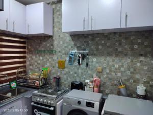 a kitchen with white cabinets and a stove top oven at UCLAS Gorgeous Apartment in Port Harcourt