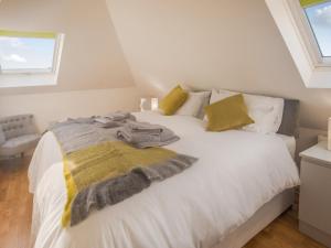 a white bed with a blanket and pillows on it at Loft Living - Ukc5413 in Broadstairs