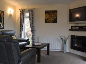 a living room with a couch and a tv and a table at Island View Lodge in Tarbert