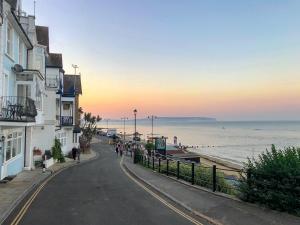 an empty street next to the ocean at sunset at Beachside Bluff in Shanklin