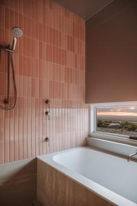 y baño con bañera y ventana. en Pod-e Luxury Accommodation - Mulla Mulla, en Streaky Bay