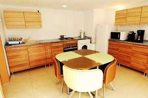 a kitchen with a wooden table and a table and chairs at Route 66 in Haţeg
