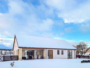 a small white house with snow on the ground at Terra Verde in Beauly