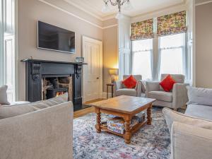 a living room with a fireplace and a tv at Reay House in Nairn