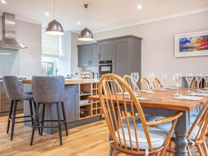 a kitchen and dining room with a wooden table and chairs at Reay House in Nairn