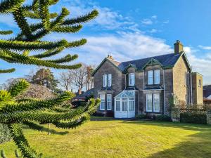 a house with a tree in front of it at Reay House in Nairn