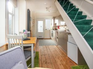 a kitchen with a table and a green staircase at The Wee One in Nairn