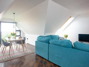 sala de estar con sofá azul y mesa en Pochin House Apartment 16 en St Austell