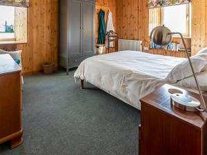 a bedroom with a bed and a desk with a lamp at Smithy Burn Croft in Rhilochan