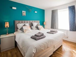 um quarto com uma grande cama branca com paredes azuis em Garden Views - Ukc5414 em Broadstairs