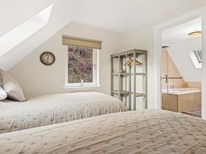 a white bedroom with a bed and a bathroom at Taigh Geal in Foyers