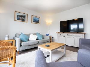 a living room with a couch and a tv at Thistledown in Dornoch