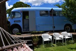 Una furgoneta azul con cuatro sillas y una puerta en Evi the school bus at Oromahoe Downs Farm, en Puketona