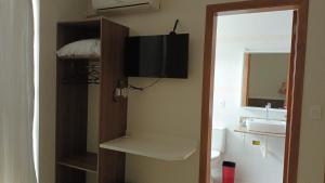 a bathroom with a sink and a toilet and a mirror at Pousada Souza & Souza in Barra Velha
