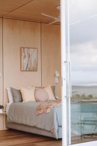 - une chambre avec un lit et des oreillers dans l'établissement Pod-e Luxury Accommodation - Mulla Mulla, à Streaky Bay