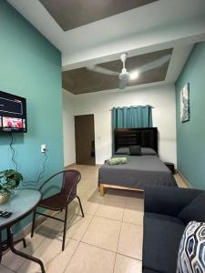 a bedroom with a bed and a couch and a table at Brisa del mar #7 in Puerto Escondido