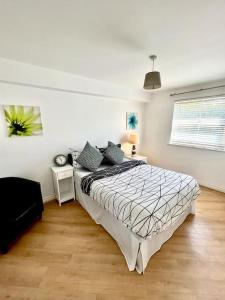 a bedroom with a bed in a white room at Chancellor Apt Nr Uni/Hosp/CityCtr & all Amenities in Liverpool