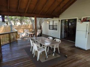 einen Tisch und Stühle auf einer Terrasse mit einem weißen Kühlschrank in der Unterkunft ATV Lakefront Paradise in Lakehills