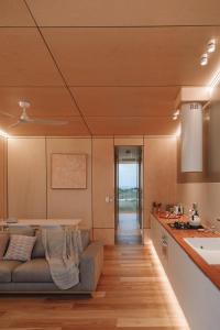 sala de estar con sofá y cocina en Pod-e Luxury Accommodation - Mulla Mulla, en Streaky Bay