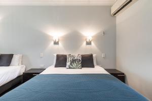 a bedroom with two beds and two lights on the wall at St Francis Winery in Old Reynella
