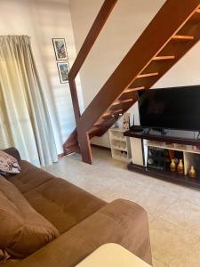 a living room with a couch and a flat screen tv at O Paraíso é aqui: Pé na Areia em Arembepe in Camaçari