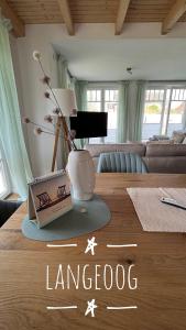 ein Wohnzimmer mit einem Tisch und einer Vase darauf in der Unterkunft Deich21-Haus Langeoog in Wangerland