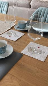 einen Tisch mit zwei Weingläsern und Schüsseln darauf in der Unterkunft Deich21-Haus Langeoog in Wangerland