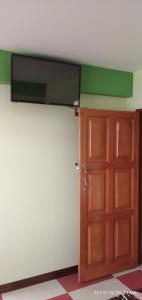 a room with a door and a television on the wall at HOSTAL ETERNA PRIMAVERA in Copacabana