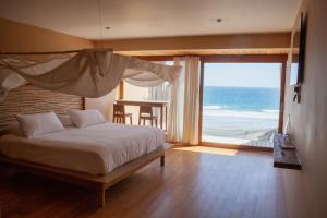 a bedroom with a bed with a view of the beach at Alma Loft in Máncora