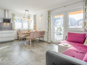 - un salon avec un canapé rose et une table dans l'établissement Blick auf den Rettenstein Top 1, à Kirchberg in Tirol