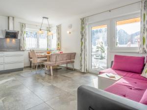 a living room with a pink couch and a table at Blick auf den Rettenstein Top 1 in Kirchberg in Tirol