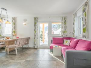 a living room with a pink couch and a table at Blick auf den Rettenstein Top 1 in Kirchberg in Tirol