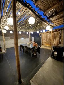 a man sitting at a table in a pavilion at Lobitos Eco Lodge in Lobitos