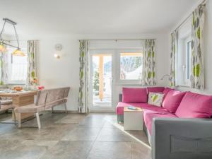 a living room with a pink couch and a table at Blick auf den Rettenstein Top 1 und 2 in Kirchberg in Tirol