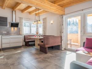 a living room with a table and a couch at Blick auf den Rettenstein Top 1 und 2 in Kirchberg in Tirol