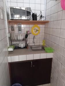 a small kitchen with a sink and a microwave at Partners Residence in Douala