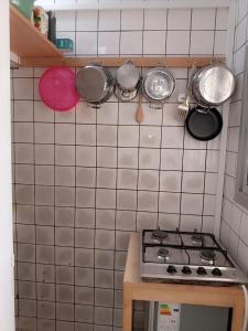 uma cozinha com panelas e frigideiras numa parede de azulejos em Partners Residence em Douala