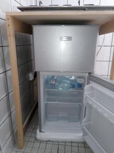 an empty refrigerator with its door open in a kitchen at Partners Residence in Douala