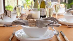 a table with a white bowl on a table with wine glasses at Sunrise Sands in Callala Beach +18 photos