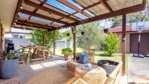 an outdoor patio with a wooden pergola at Sunrise Sands in Callala Beach