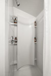 a white bathroom with a shower and a sink at Cute 1bdrm Cottage in Downtown Tampa in Tampa