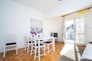 une salle à manger blanche avec une table et des chaises dans l'établissement Apartments by the sea Sukosan, Zadar - 5863, à Sukošan