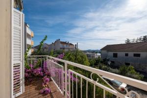 Elle comprend un balcon doté d'une balustrade blanche et de fleurs violettes. dans l'établissement Apartments by the sea Sukosan, Zadar - 5863, à Sukošan