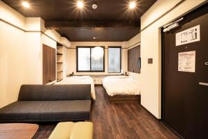 a room with a couch and a bed and a window at かゑる屋 in Kobe