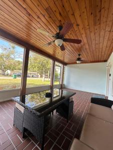 a screened in porch with a ceiling fan and a table at Seashell House in Clearwater