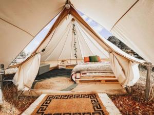 ein Schlafzimmer mit einem Bett in einem Zelt in der Unterkunft Silversprings cottages in Metricup