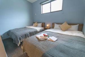 a bedroom with two beds with flowers on them at なでしこ町家 in Fukuoka